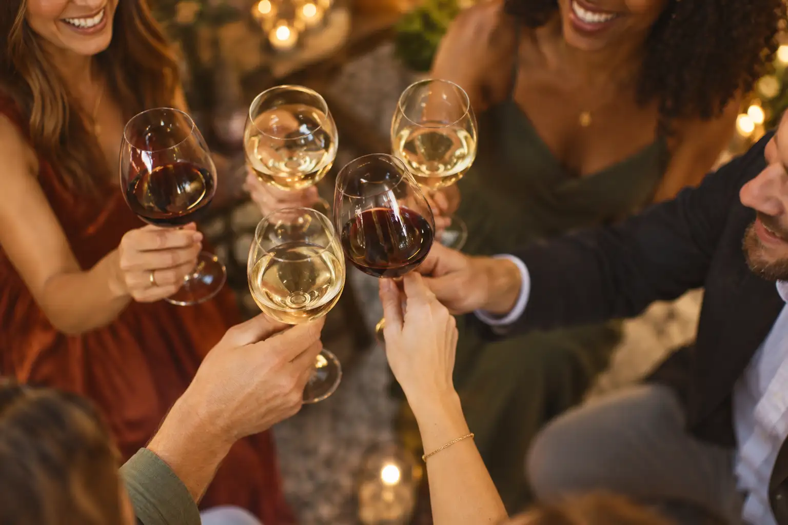 Wine glasses meeting in a toast, seen from above