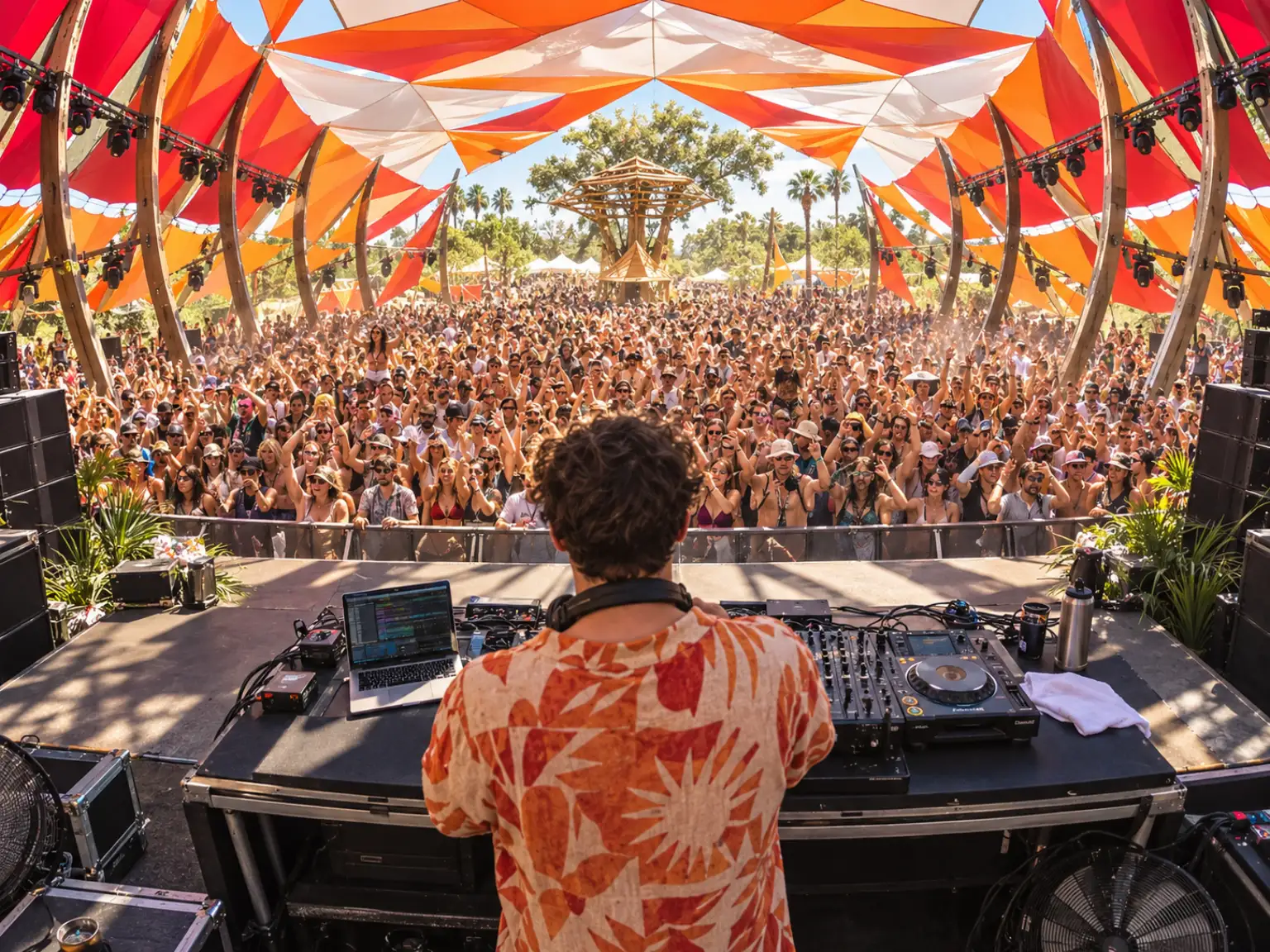 A crowd facing a stage at an outdoor festival in daylight